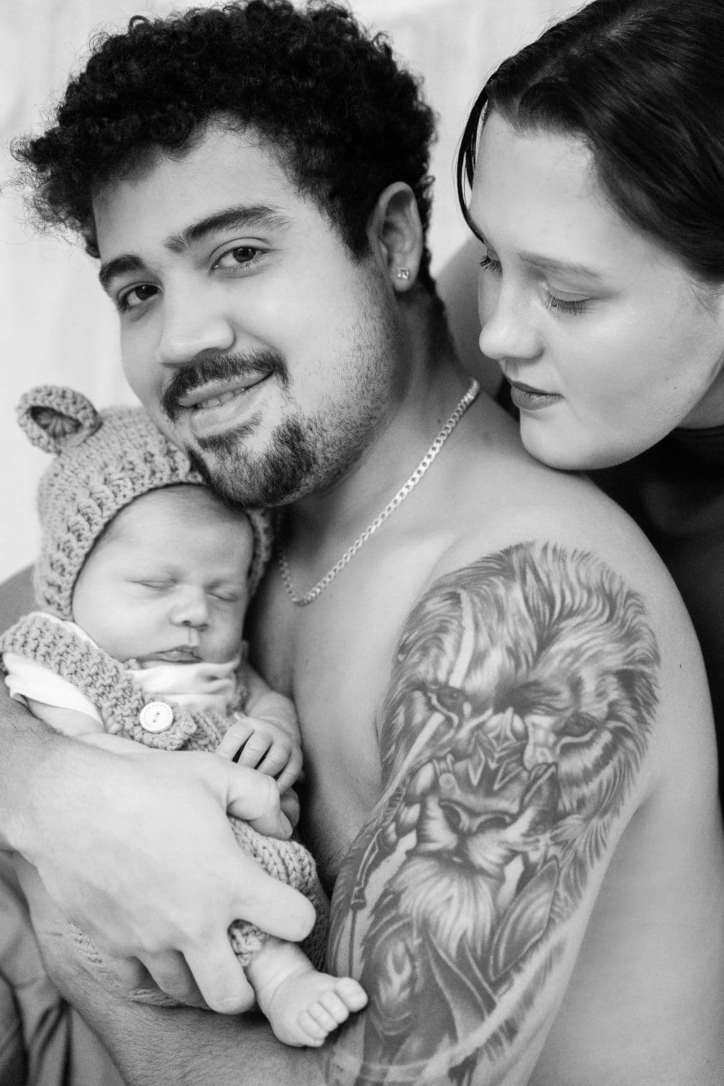 Parents with newborn in knitted outfit