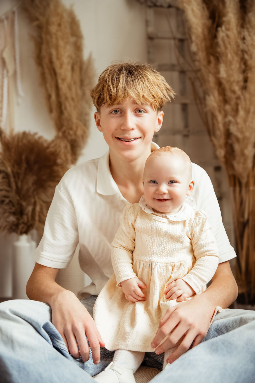 Older sibling holding baby in studio